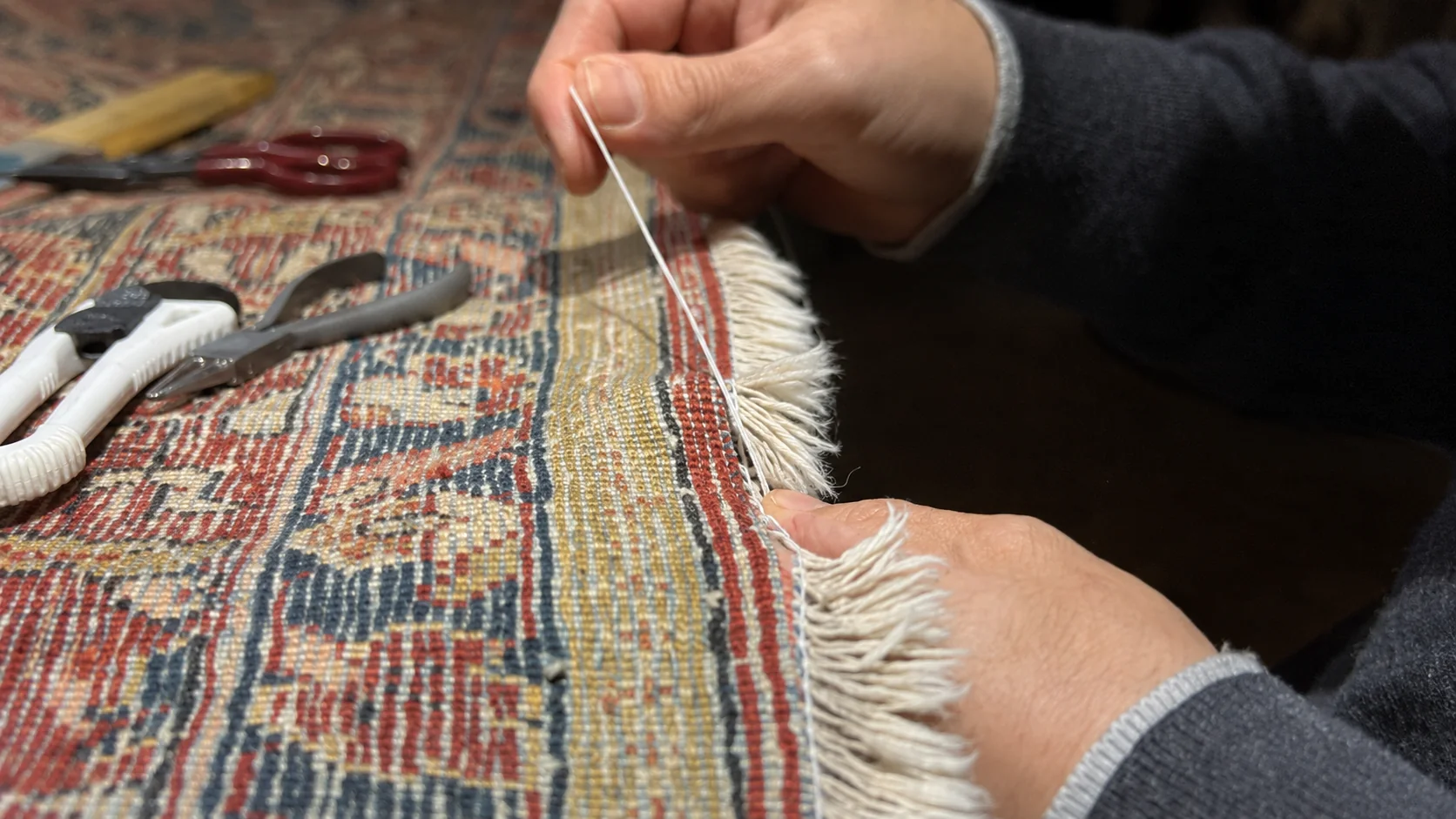 Riparazione a mano delle frange di un tappeto